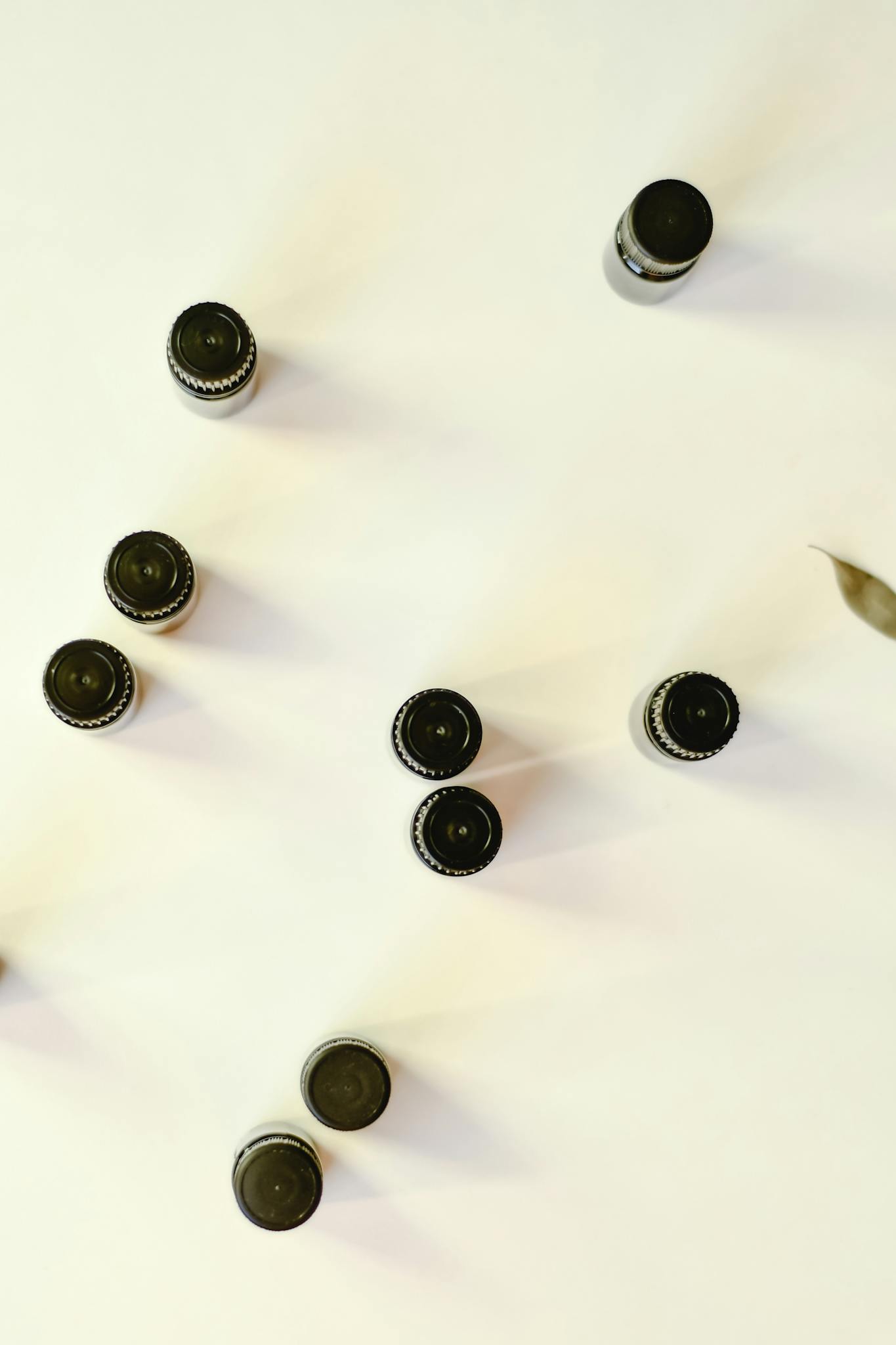 Top view of essential oil bottles arranged on a white surface, perfect for aromatherapy concepts.
